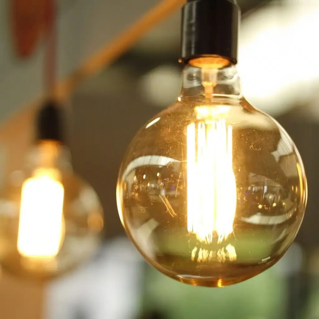 lâmpada de filamento incandescente acesa — história da eletricidade e energia solar